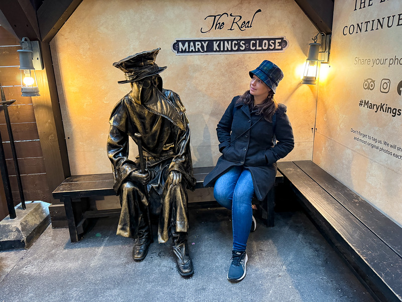 Lina Stock sitting with a plague doctor statue in Edinburgh, Scotland