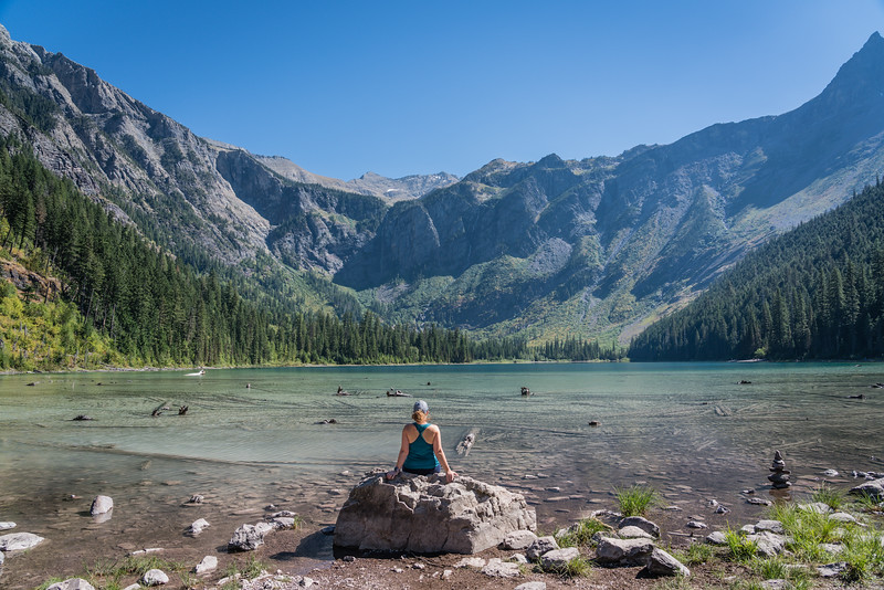 Lina Stock of 8 Wonders of the World Adventure Travel Blog taking in the views at Avalanche Lake on a summer day.