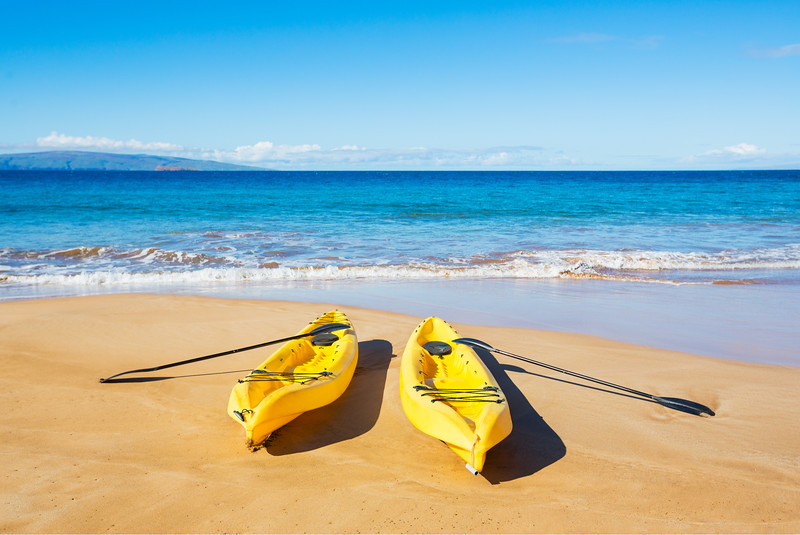 Two yellow kayaks on a beach in Maui
